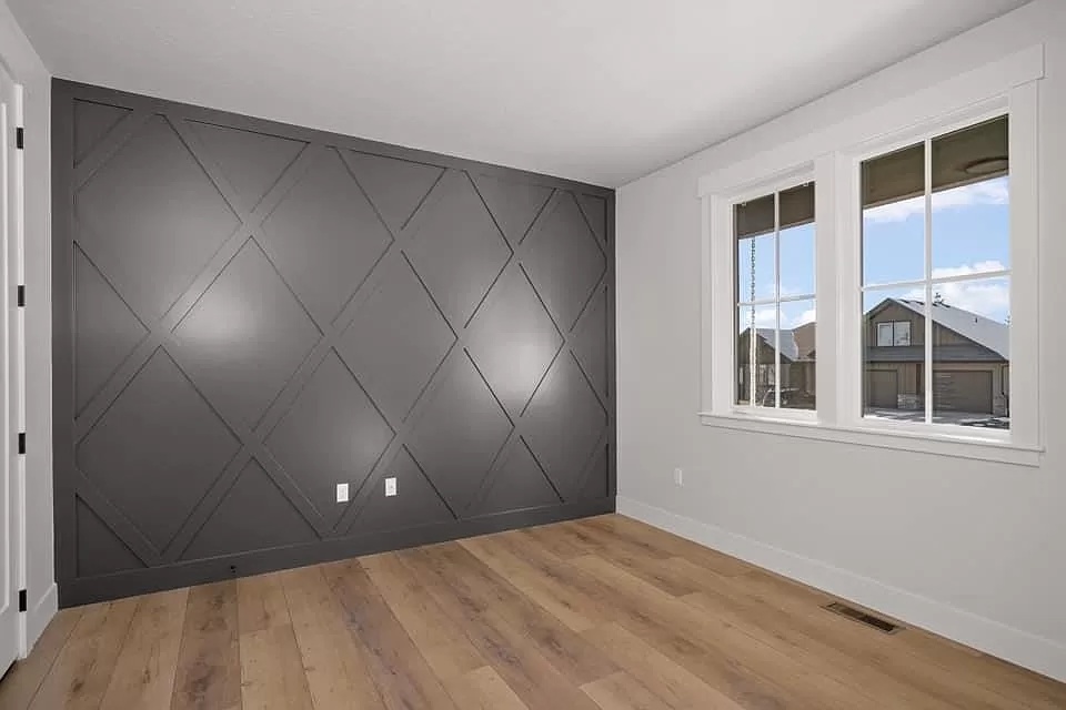 Bedroom with gray diamond board and batten accent wall and light LVP flooring