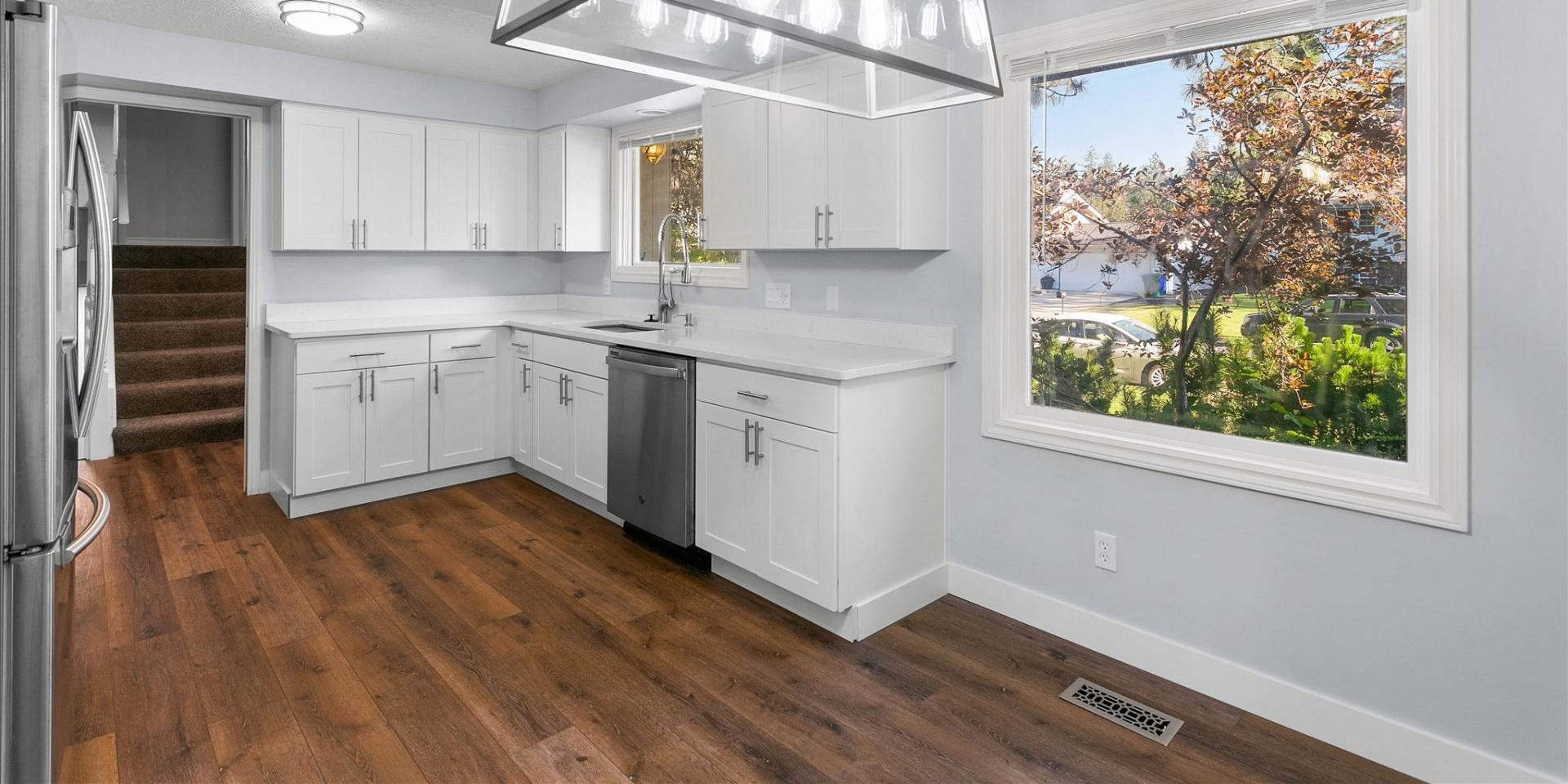 Renovated kitchen with white shaker cabinets and hardwood floors
